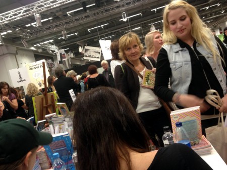 Lång kö till signering med Nanna Johansson på bokmässan 2013. Väntade gjorde bland annat Emilia Wiklund (längst fram) och Ann Helen (längre bak). Foto: Malinda Lindmark.