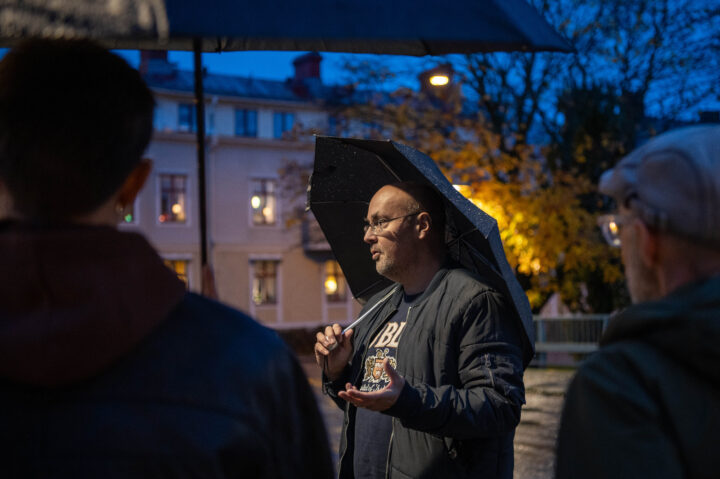 Victor Estby berättar om Åmåls historia under ett paraply